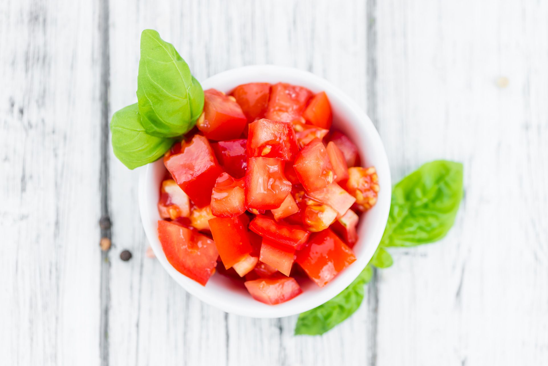 Recipiente bianco con pomodoro cubettato